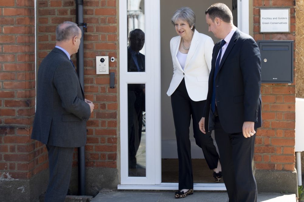 British Conservative Prime Minister Theresa May, center, leaves the Finchley and Golders Green Conservatives Association in north London, Britain, on Friday. — EPA