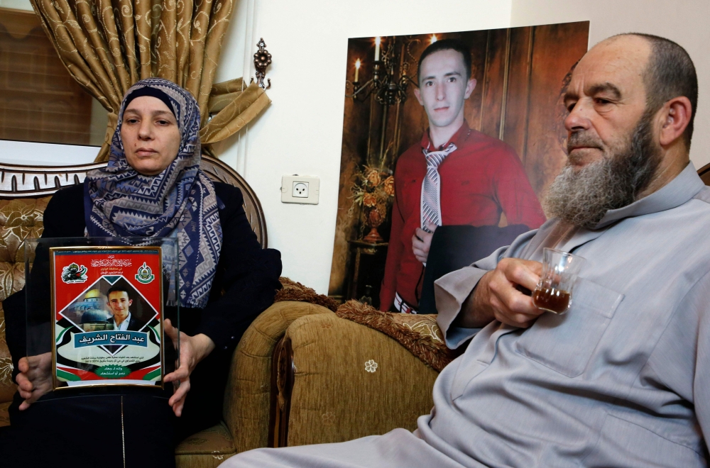 Abdul Fatah Al-Sharif and Raja the grandfather and mother of Abdul Fatah Al-Sharif who was shot dead by Israeli soldier Elor Azaria while lying wounded on the ground in 2016, sits at their home in the West Bank town of Hebron, as Azaria was freed from prison on Tuesday after serving just nine months behind bars. — AFP