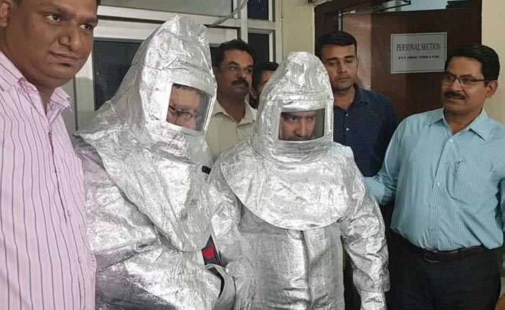 In this photograph released by the Delhi Police, Indian officials stand alongside a father and son duo dressed in 