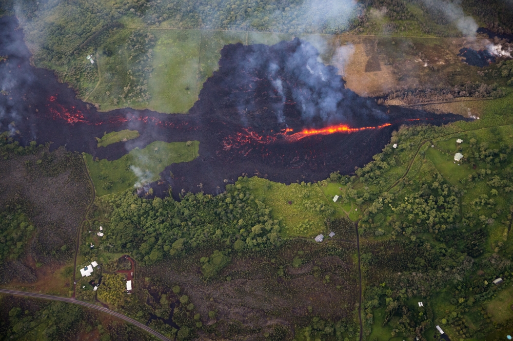 An aerial view shows eruptive activity continuing at fissure 17, as lava from that vent advanced roughly a mile, covering property, mainly pastureland, but is now encroaching upon two major thoroughfares, and a number of homes, in Pahoa, Hawaii, on Monday. — EPA