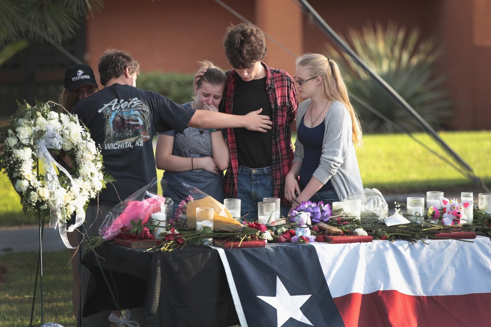 Santa Fe High School students gather at a makeshift memorial during a community dinner put on by volunteers to help residents begin healing in Santa Fe, Texas, on Saturday. — AFP