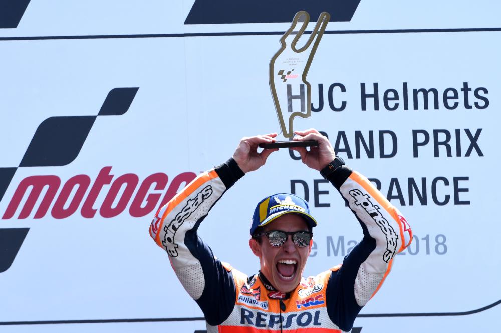 Repsol Honda Team's Spanish rider Marc Marquez celebrates on the podium with the trophy after winning the MotoGP race of the French motorcycling Grand Prix in Le Mans, northwestern France, Sunday. — AFP