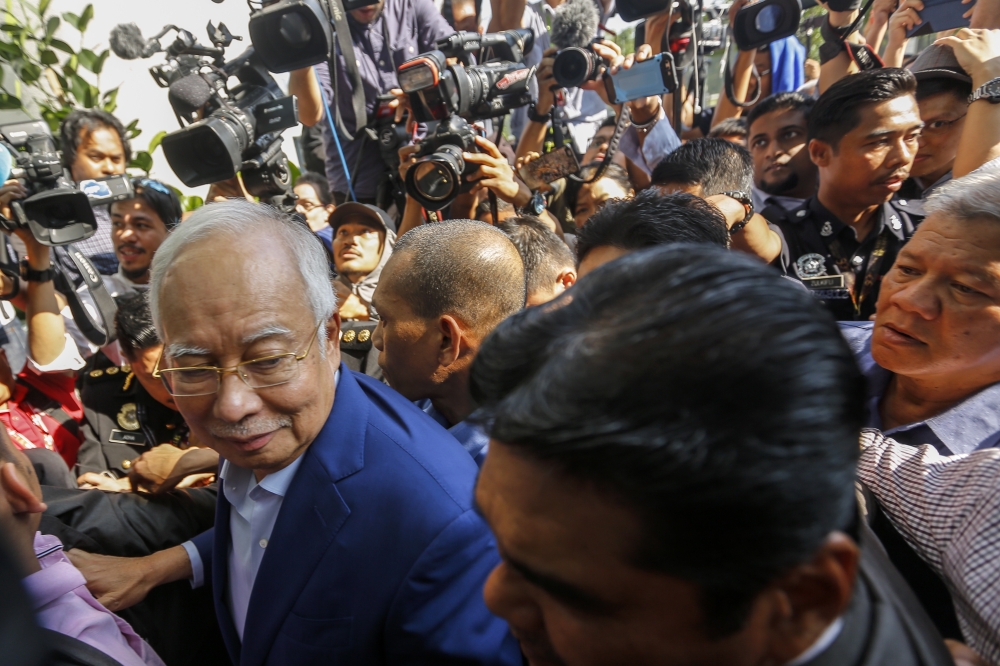 Former Malaysia Prime Minister Najib Razak, left, surrounded by media as he arrives at the Malaysian Anti-Corruption Commission (MACC) in Putrajaya, Malaysia, on Tuesday. — EPA