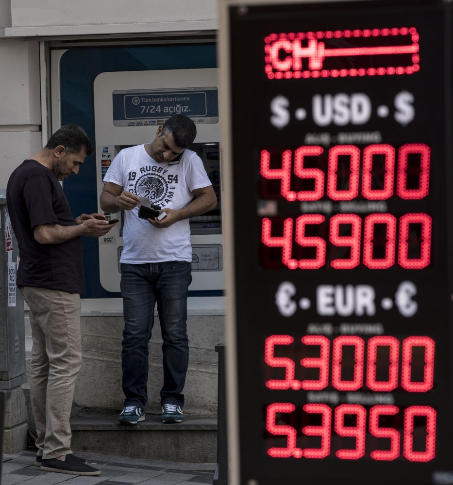People exchange money at a currency exchange office in Istanbul, Turkey. — EPA
