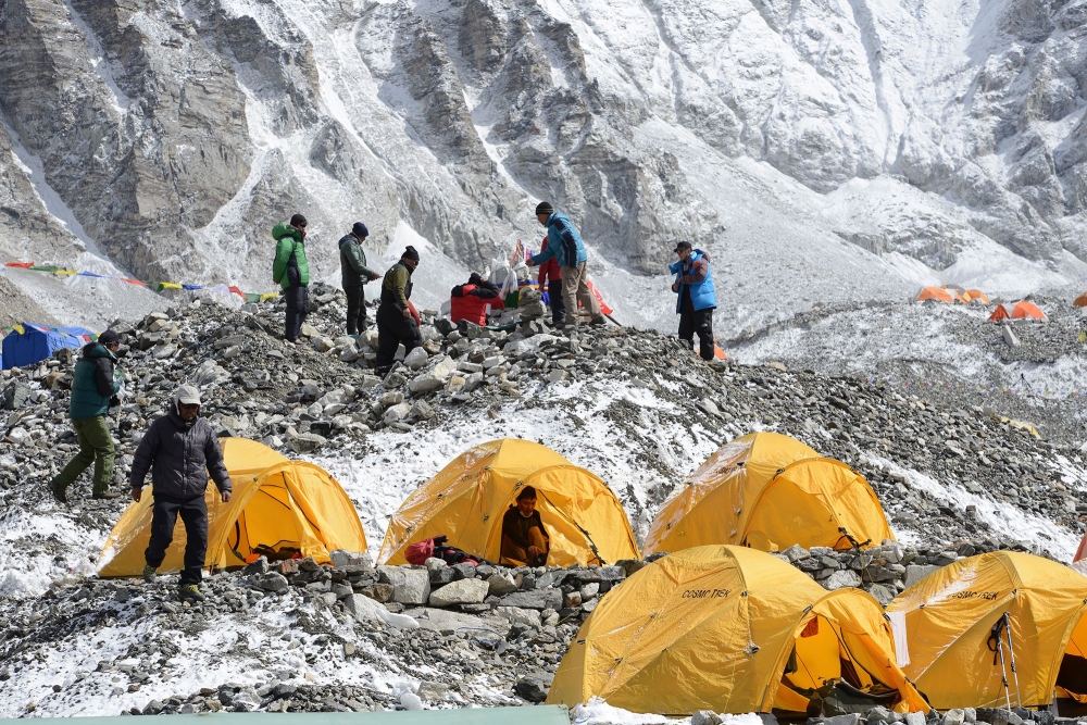 Sherpa guides (top) prepare for a ritual to pay respects to Mount Everest before beginning their climb, as other climbers look on by their tents at Everest base camp, some 140 km northeast of Kathmandu. Wi-Fi, baked goods and trendy coffee: gone are the days of deprivation at Everest base camp, with hipster perks and modern conveniences ensuring life is cushier than ever on the roof of the world. — AFP