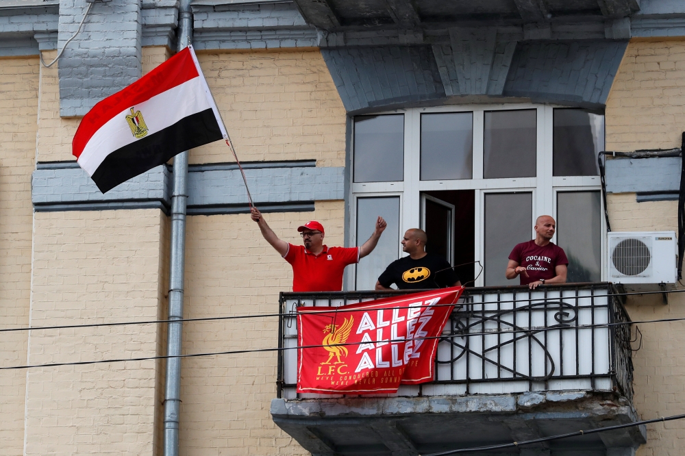 A Liverpool fan waves an Egypt flag from a balcony in Kiev as the team gets set to face Real Madrid in the Champions League final on Saturday, the same day when Egypt plays Kuwait in a friendly prior to the World Cup. — Reuters