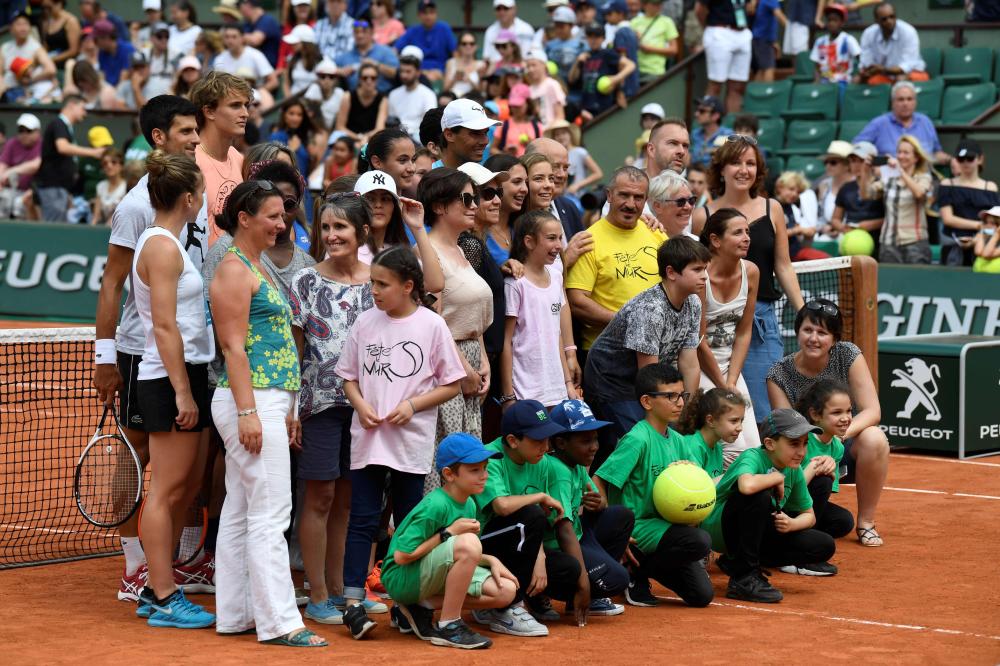 Romania’s Simona Halep (L), Serbia’s Novak Djokovic (2nd L), Germany’s Alexander Zverev (3rd L) and Spain’s Rafael Nadal (C) pose with children after an exhibition game during ‘Kids Day’ on The Philippe Chatrier Court in Paris, on the eve of The Roland Garros 2018 French Open Tennis Tournament. — AFP 
