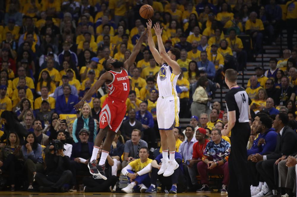 Klay Thompson of the Golden State Warriors takes a three-point shot as James Harden of the Houston Rockets defends during Game 6 of the Western Conference finals in the 2018 NBA Playoffs at Oracle Arena in Oakland Saturday. — AFP