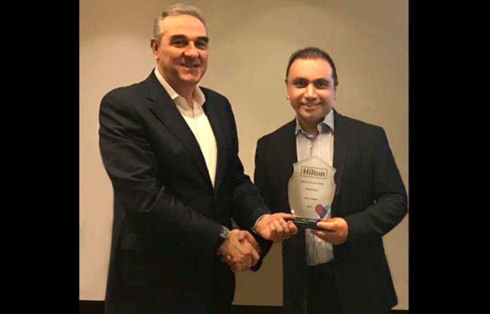 Inayat Ramjean, Director of Business Development of the Jeddah Hilton and the Waldorf Astoria Jeddah – Qasr Al Sharq, receiving the award from Kamel Ajami, Vice President Operations of Hilton KSA & Levant.