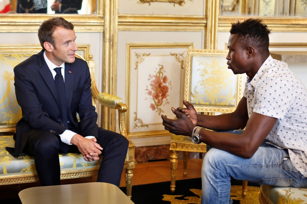French President Emmanuel Macron, left, speaks with Mamoudou Gassama, 22, from Mali, at the presidential Elysee Palace in Paris, on Monday. — AFP