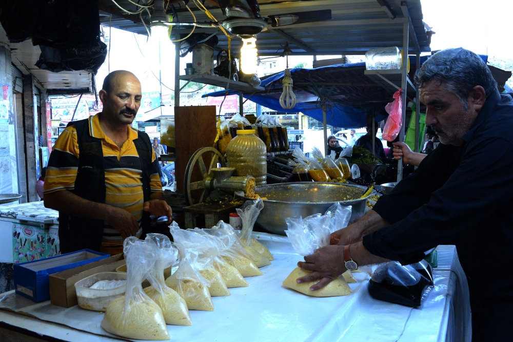 An Iraqi man buys food in an open air market after breaking the fast during the holy month of Ramadan in Mosul. — AFP
