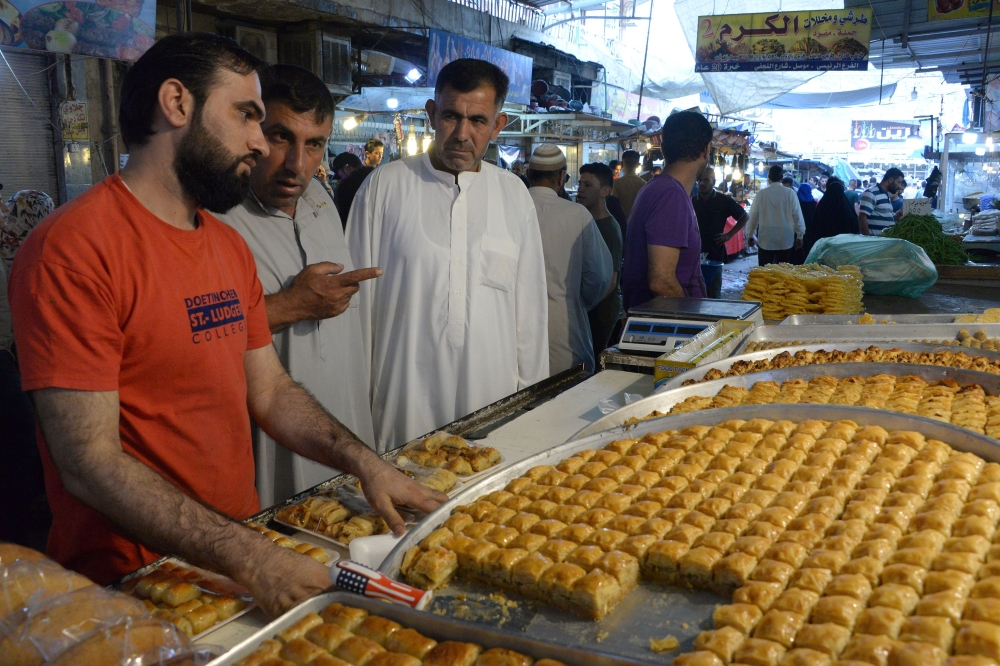 An Iraqi man buys food in an open air market after breaking the fast during the holy month of Ramadan in Mosul. — AFP