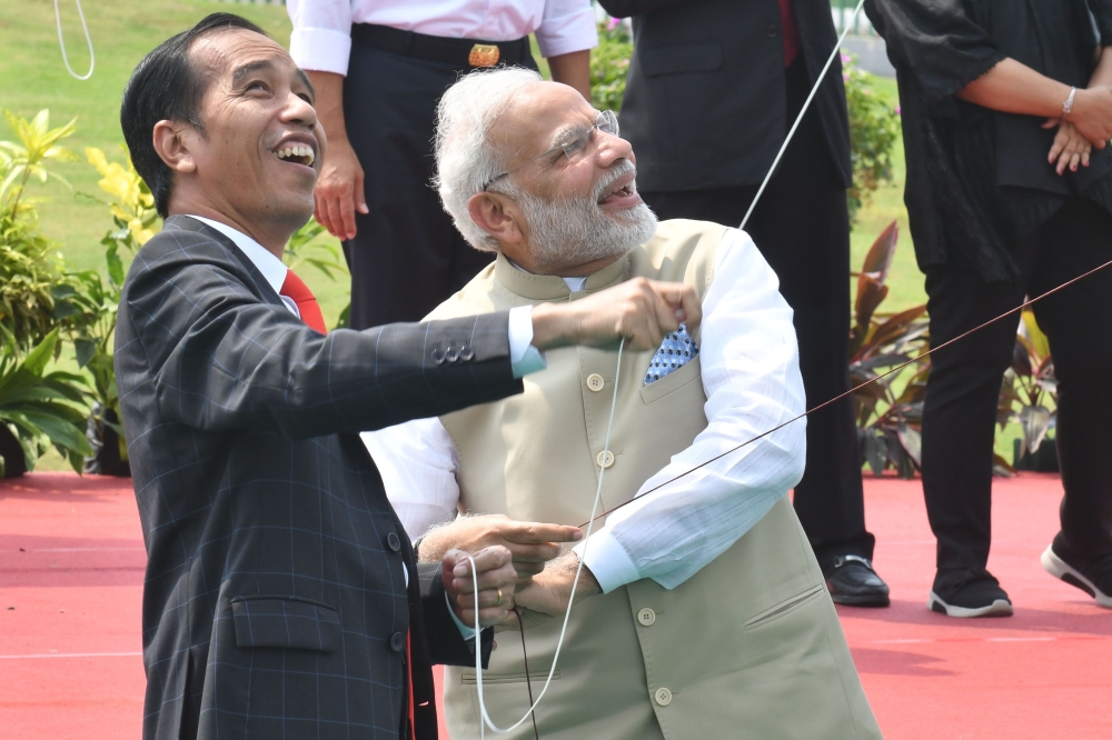 Indonesia’s President Joko Widodo, left, and India’s Prime Minister Narendra Modi fly their kites after launching the India-Indonesia kite exhibition at the National Monument in Jakarta on Wednesday. — AFP