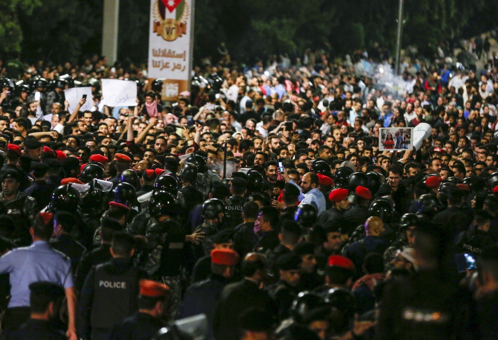 Jordanian protesters shout slogans before members of the gendarmerie and security forces during a demonstration outside the Prime Minister's office in the capital Amman. — AFP