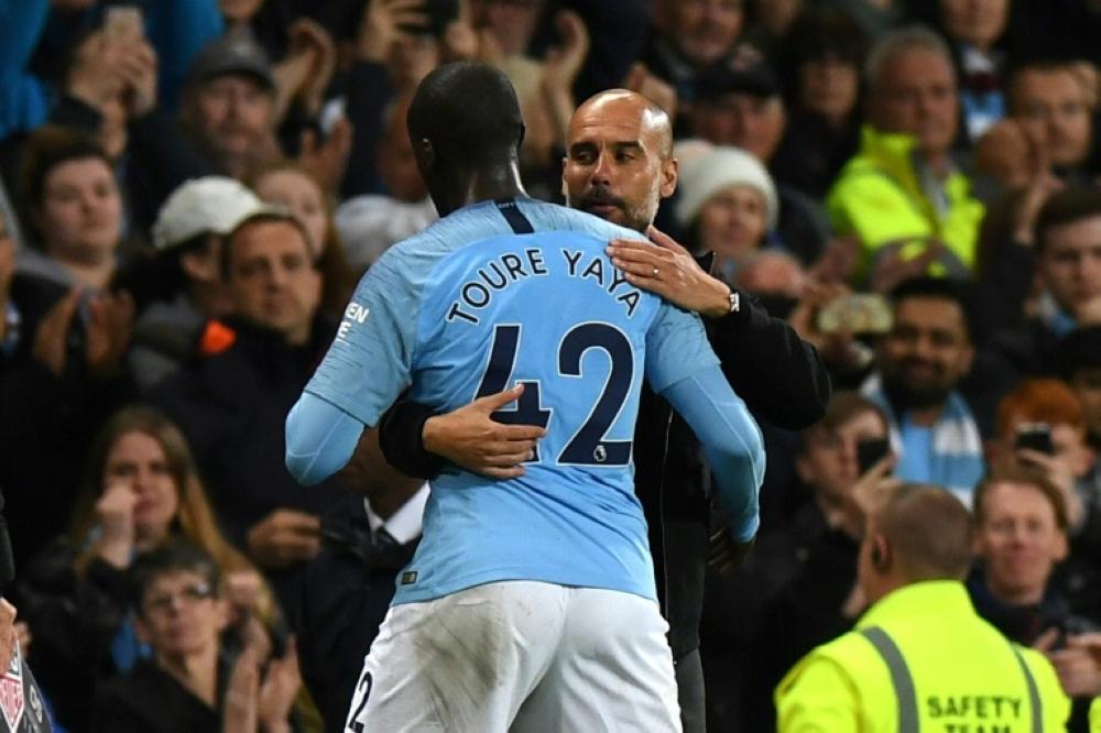 Manager Pep Guardiola embraced Yaya Toure as the midfielder came off with four minutes left in Manchester City's last home game of the season. — AFP