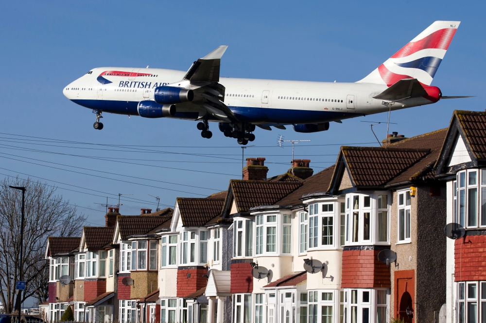 A British Airways 747 aircraft flies over rooftops as it comes into land at Heathrow Airport in west London in this Feb. 18, 2015 file photo. — AFP