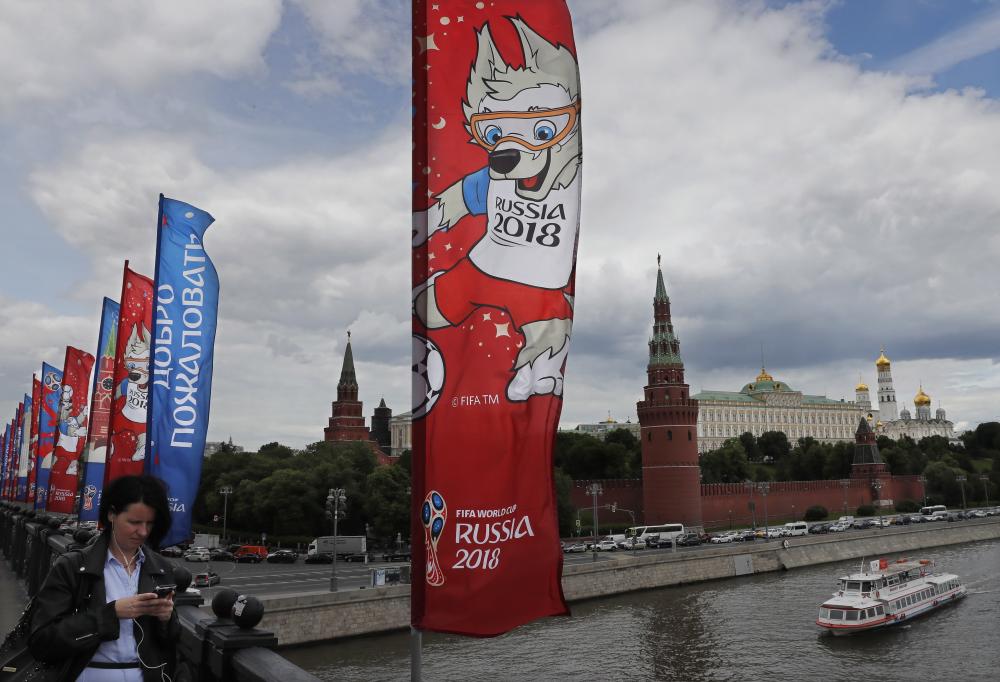 A woman walks near flags with the logo of the FIFA World Cup 2018 in Moscow. — EPA