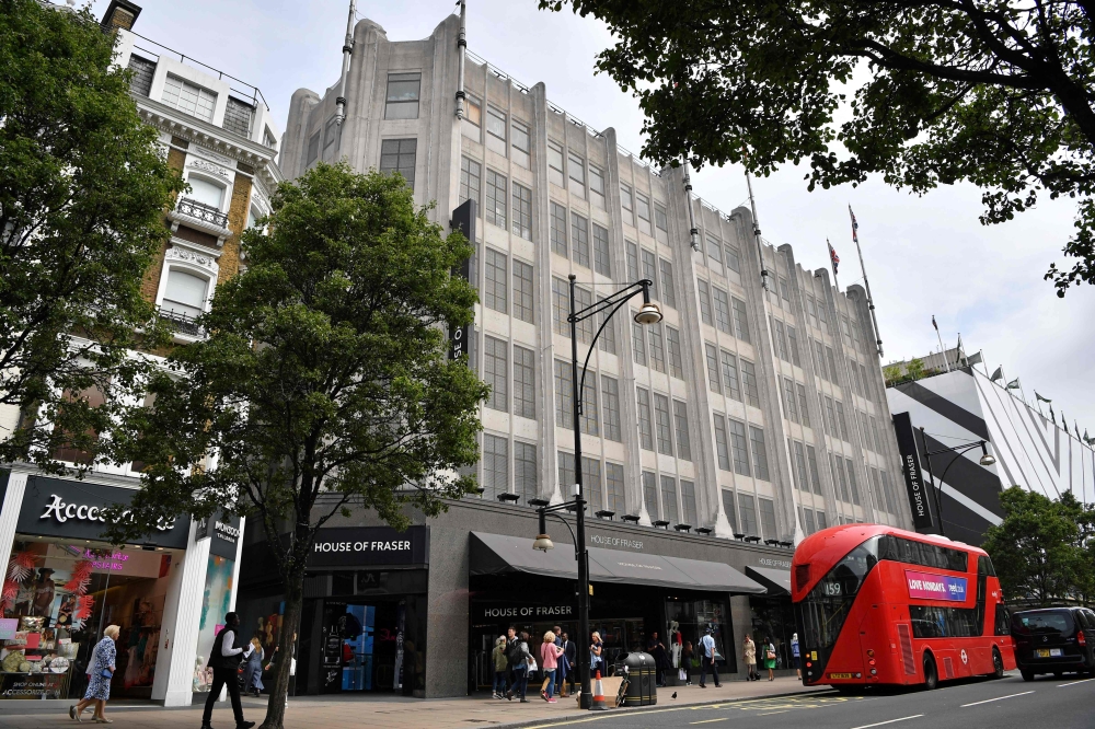 Pedestrians walk past the entrance to House of Fraser department store on Oxford Street in London on Thursday. Britain's department store chain House of Fraser, majority owned by Chinese conglomerate Sanpower, announced that it will close more than half of its branches in a rescue deal that places 6,000 jobs at risk. House of Fraser, which has suffered from high costs and fierce online competition, said in a statement that it will shutter 31 of its 59 stores in the UK and Ireland. — AFP