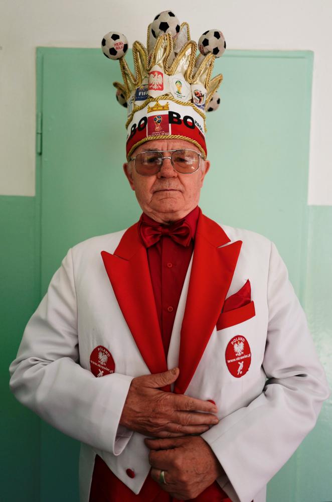 Andrzej “Bobo” Bobowski, known as “the King of Polish fans” poses for a picture inside an apartment building in Warsaw Wednesday. — Reuters
