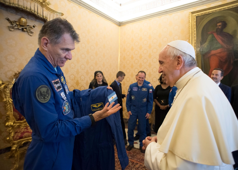 Pope Francis receives an astronaut suit from Italian astronaut Paolo Nespoli during a private meeting with crew members of the ISS 53 space mission at the Vatican on Saturday. - Reuters