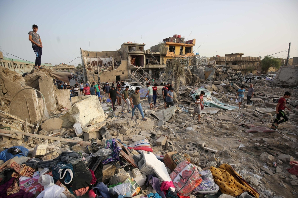 Iraqis inspect the aftermath of an explosion in Baghdad's Sadr City district on Thursday. — AFP