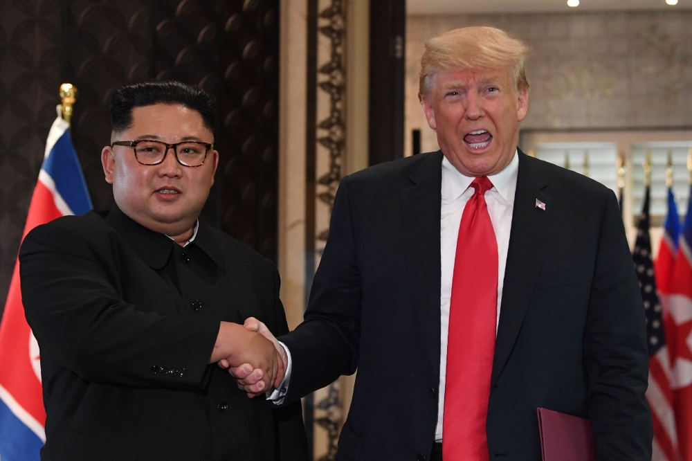 US President Donald Trump, right, and North Korea’s leader Kim Jong Un shake hands following a signing ceremony during their historic US-North Korea summit, at the Capella Hotel on Sentosa island in Singapore on Tuesday. — AFP