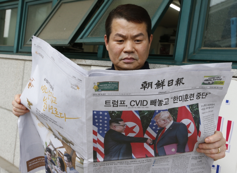 A South Korean looks at a newspaper reporting about the summit between US President Donald J. Trump and North Korean leader Kim Jong-un; in Seoul, South Korea, on Wednesday. — EPA