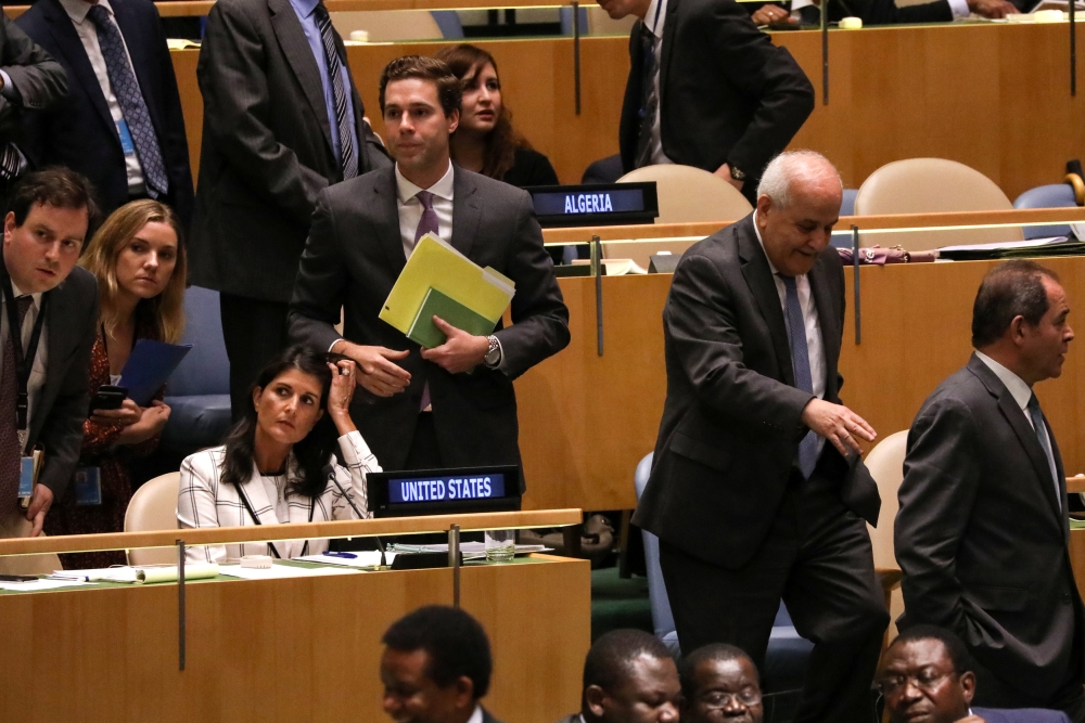 Palestinian Ambassador to the United Nations Riyad Mansour, second from right, passes US Ambassador Nikki Haley, seated left, during a vote on the adoption of a draft resolution by the United Nations General Assembly to deplore the use of excessive force by Israeli troops against Palestinian civilians at UN headquarters in New York on Wednesday. — Reuters