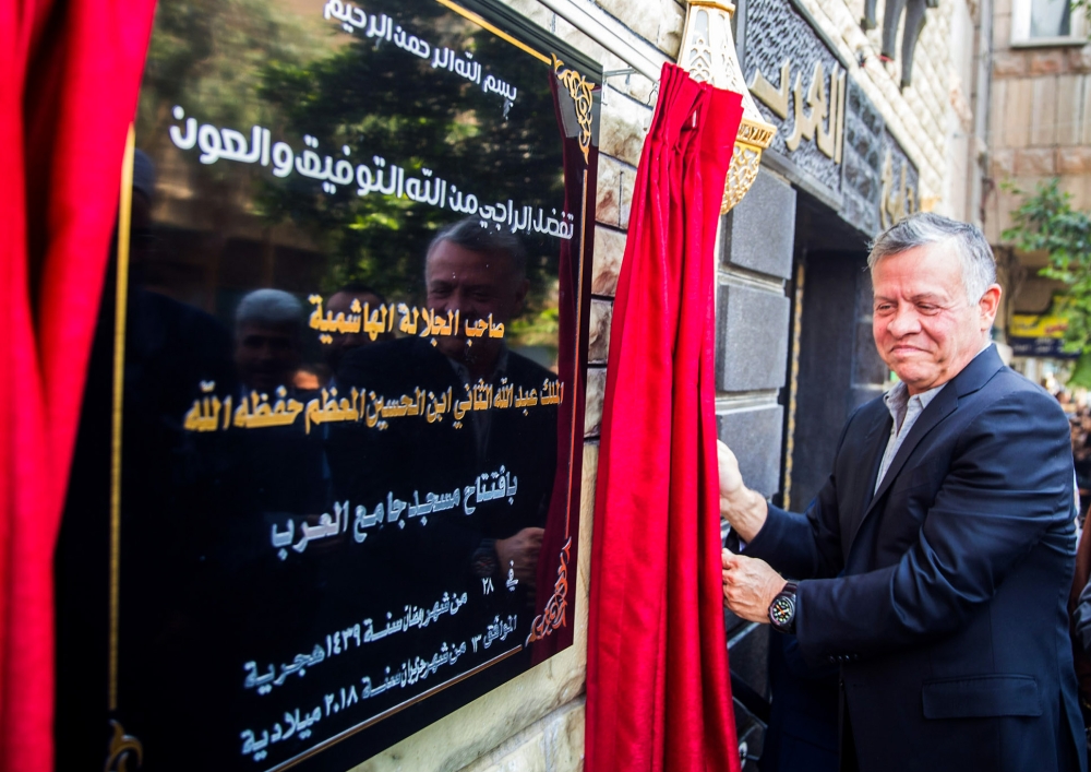 A handout picture released by the Jordanian Royal Palace on Wednesday shows Jordan’s King Abdallah unveiling a plaque at the newly-inaugurated Al-Arab Mosque in Zarqa, 30 km east of the capital Amman. — AFP