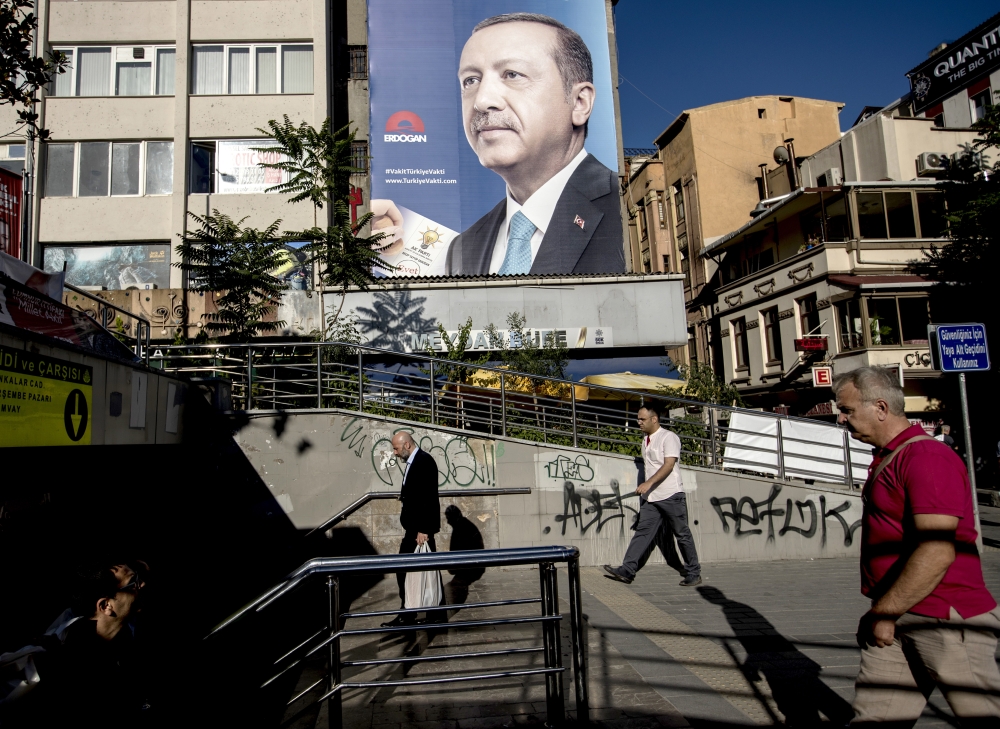 People walk in front of a banner depicting Turkish President Recep Tayyip Erdogan in Istanbul, Turkey, on Wednesday. — EPA