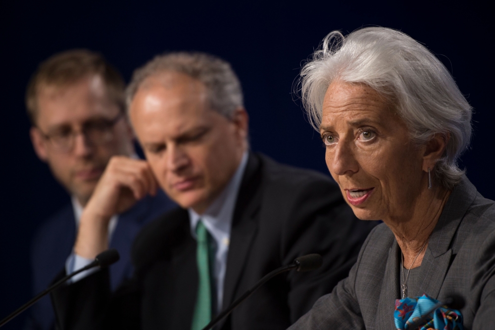 The International Monetary Fund (IMF) managing director, Christine Lagarde talks about the IMF's preliminary findings of its annual review of the US economy as Director of the Western Hemisphere, Alejandro Werner (C),  and Deputy Division Chief of the Western Hemisphere, Daniel Leigh (L) look on during a news conference  in Washington DC on Thursday. — AFP