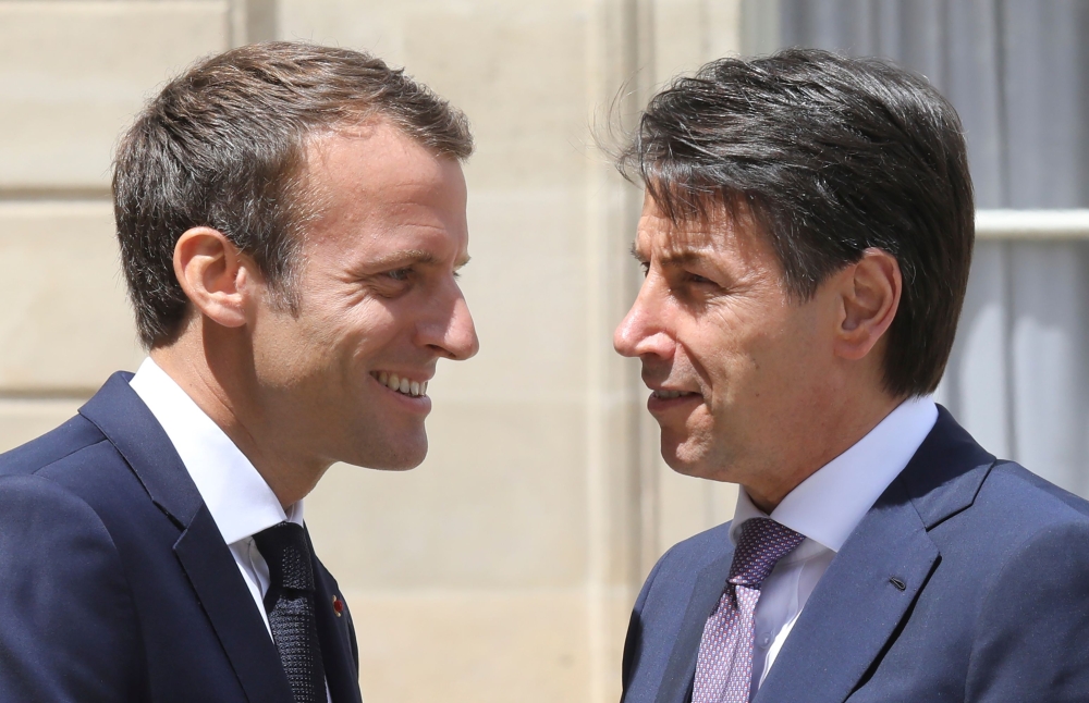 French President Emmanuel Macron, left, welcomes new Italian Prime Minister Giuseppe Conte, right, before a meeting at the Elysee Palace in Paris on Friday. — AFP