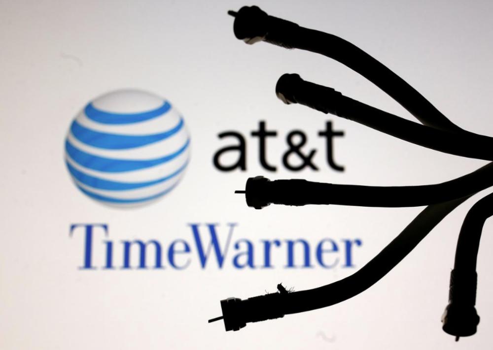 Coaxial TV Cables are seen in front of AT&T and Time Warner logos in this picture illustration. — Reuters