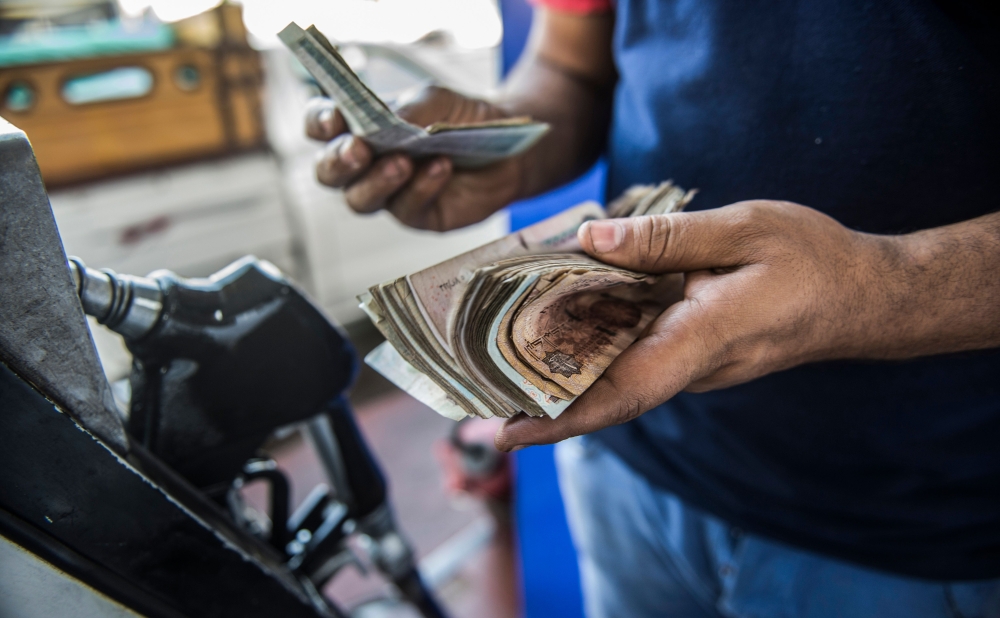 In this file photo an Egyptian petrol station worker counts cash collected from customers, in the capital Cairo. Egypt announced new price hikes of between 35 and 50 percent on fuel on Saturday as part of austerity measures tied to an IMF loan as it seeks to cut subsidies and reduce its public debt. — AFP