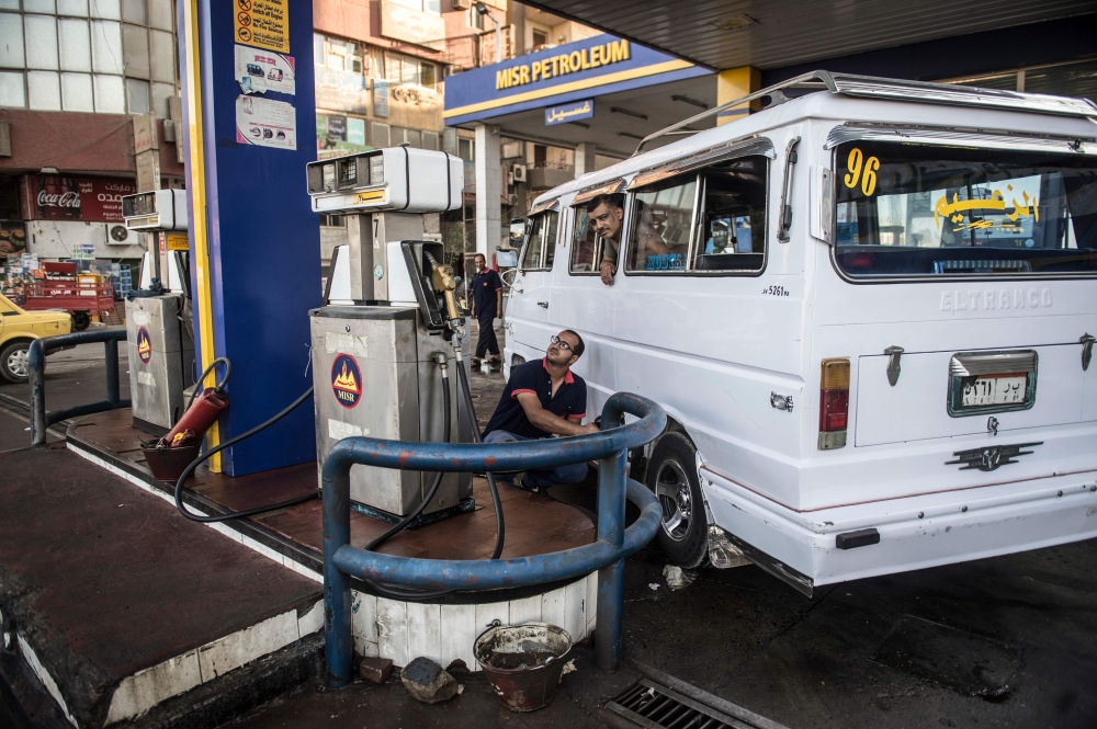 In this file photo an Egyptian petrol station worker counts cash collected from customers, in the capital Cairo. Egypt announced new price hikes of between 35 and 50 percent on fuel on Saturday as part of austerity measures tied to an IMF loan as it seeks to cut subsidies and reduce its public debt. — AFP