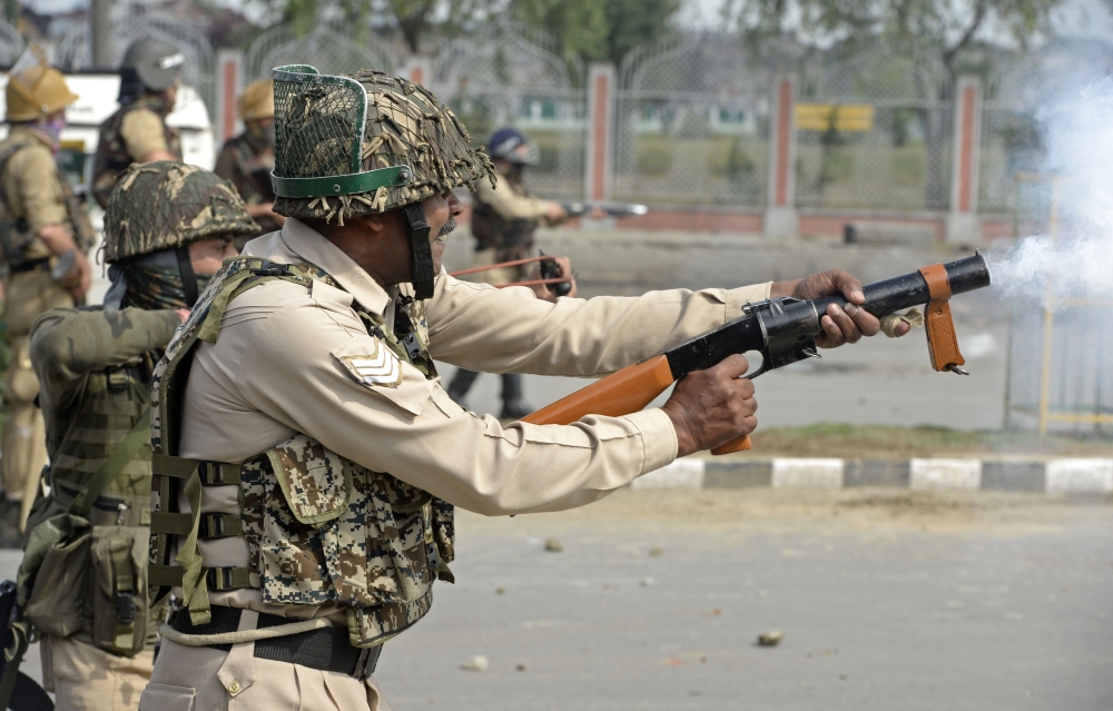 Indian paramilitary trooper fires tear smoke shells during clashes in Srinagar on Saturday. — AFP