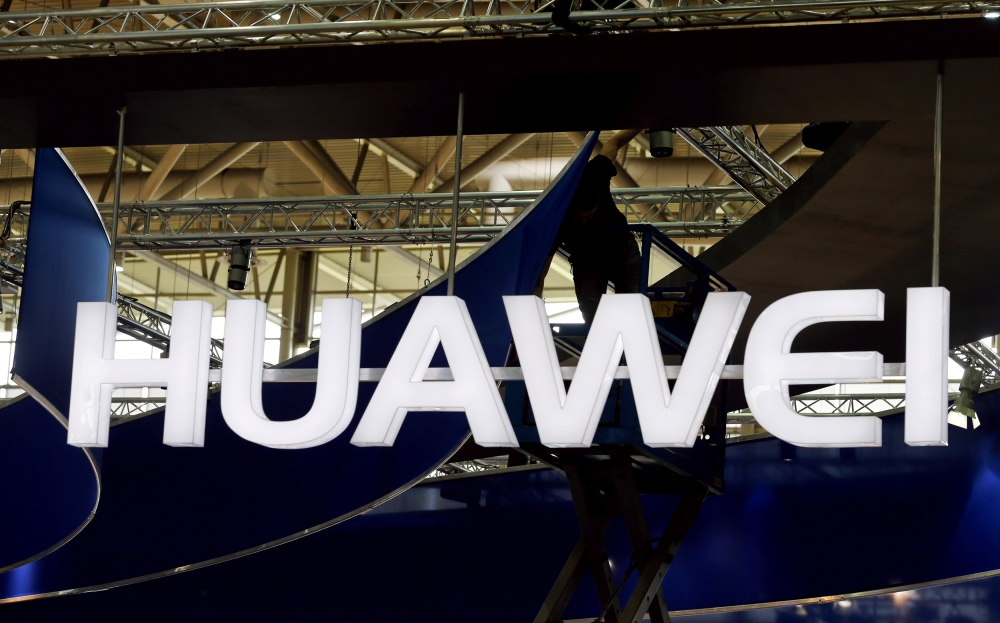 A worker adjusts the logo at the stand of Huawei at the CeBIT trade fair in Hanover, in this file picture. — Reuters