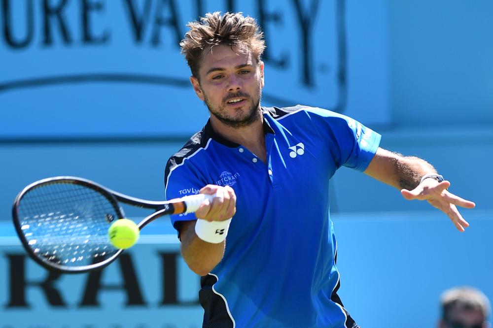 Switzerland's Stan Wawrinka plays a forehand return to Britain's Cameron Norrie during their first round match at the ATP Queen's Club Tennis Championships in west London Monday.  — AFP