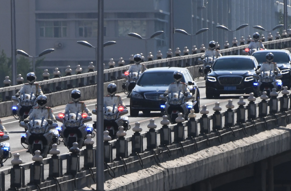 The car, center, believed to be carrying North Korean leader Kim Jong Un is escorted by motorcycles in Beijing on Tuesday. — AFP