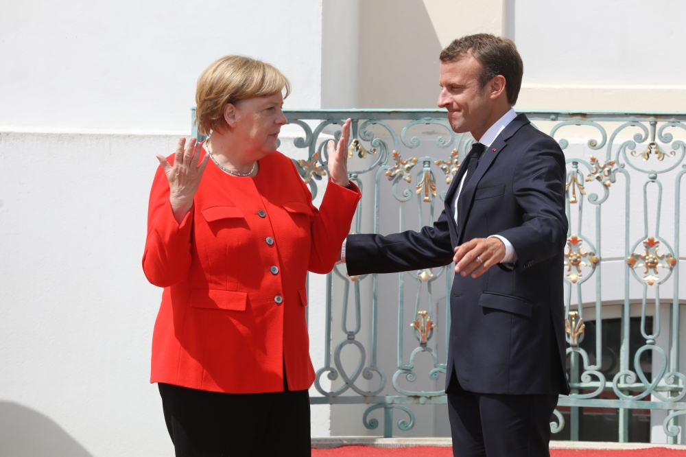 German Chancellor Angela Merkel, left, gestures as she welcomes French President Emmanuel Macron at the Meseberg Palace, northeastern Germany, on Tuesday. — AFP