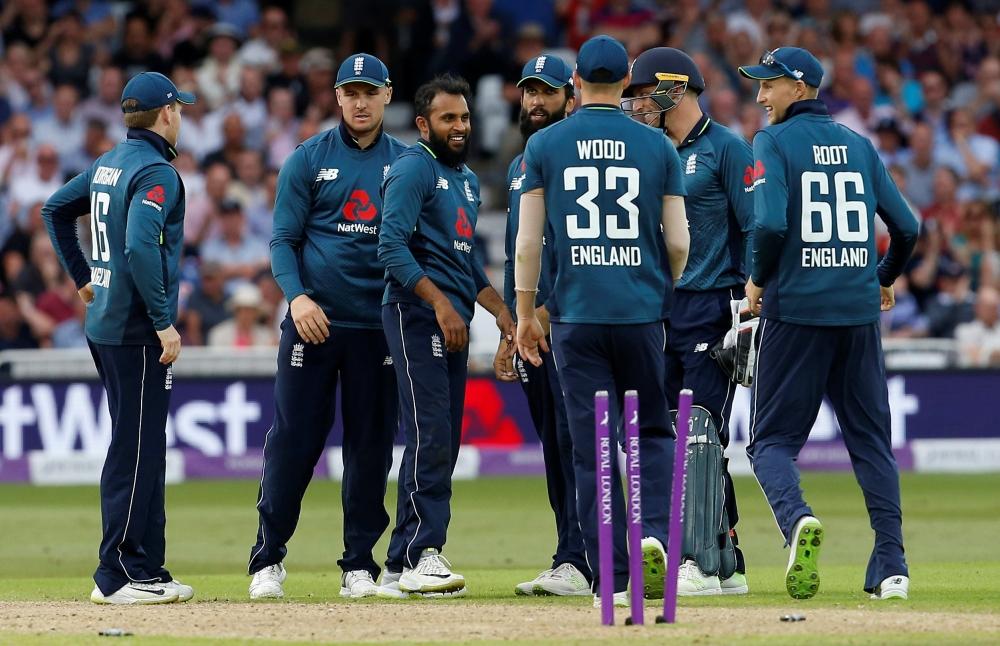 England's Adil Rashid celebrates with team mates after taking the wicket of Australia's Aaron Finch. — Reuters