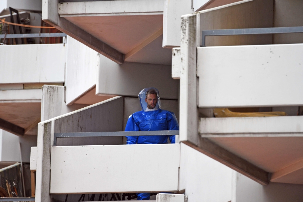 A German forensic expert in protective clothes stands on a balcony of an apartment building in Cologne’s Chorweiler district, where a Tunisian suspected of trying to build a biological weapon was arrested in this June 15, 2018 file photo. — AFP