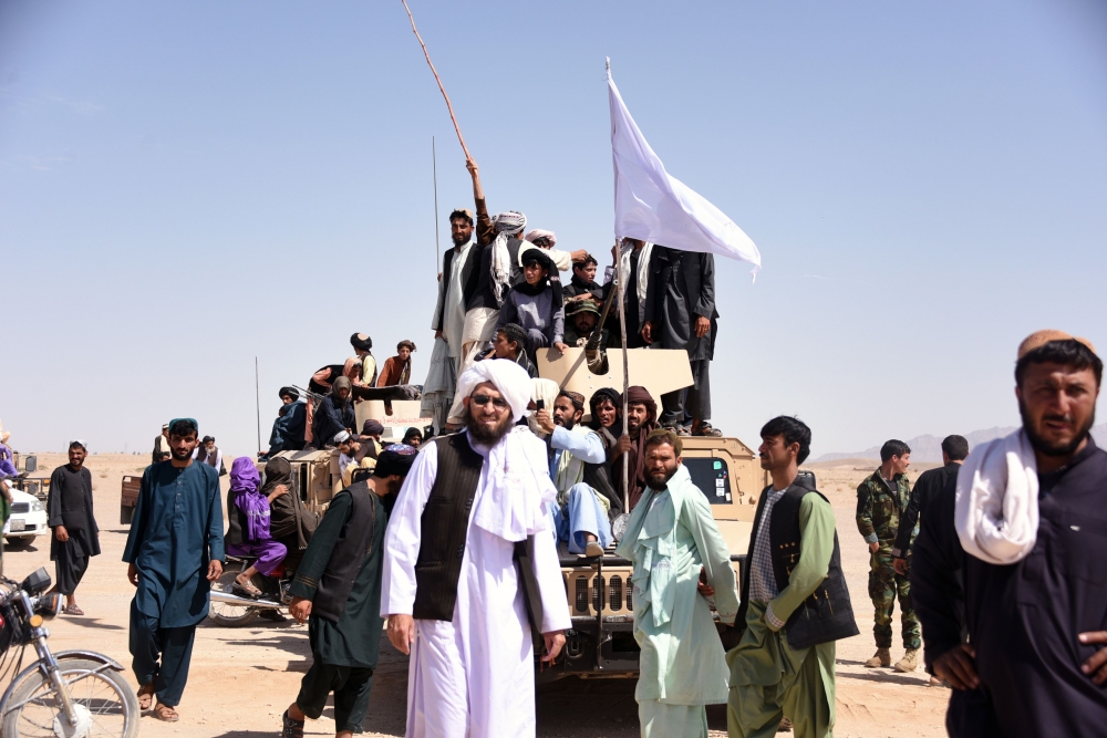 Afghan Taliban militants and residents stand on a armored Humvee vehicle of the Afghan National Army (ANA) as they celebrate ceasefire on the third day of Eid in Maiwand district of Kandahar province in this June 17, 2018 file photo. — AFP