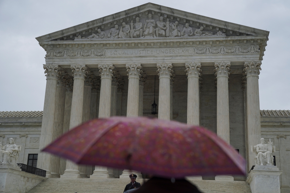 A person walks with an umbrella prior to the US Supreme Court's decision to impose limits on the ability of police to obtain cellphone data pinpointing the past location of criminal suspects, outside the US Supreme Court in Washington, US.— Reuters