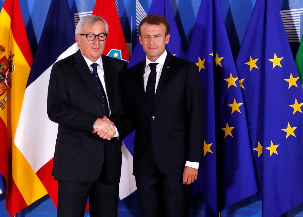 French President Emmanuel Macron is welcomed by European Commission President Jean-Claude Juncker at the start of an emergency European Union leaders summit on immigration at the EU Commission headquarters in Brussels, Belgium, on Sunday. — Reuters