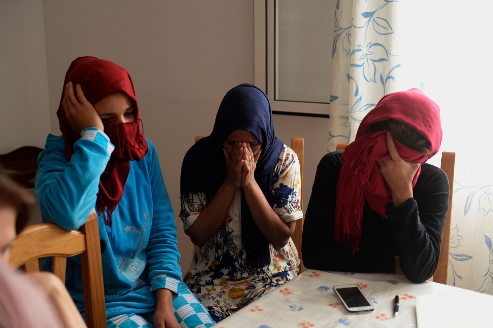 Moroccan strawberry pickers, who denounced their working conditions and filed sexual harassment complaints, gesture during an interview at their shelter near Malaga. — AFP