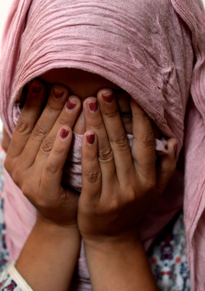 Moroccan strawberry pickers, who denounced their working conditions and filed sexual harassment complaints, gesture during an interview at their shelter near Malaga. — AFP