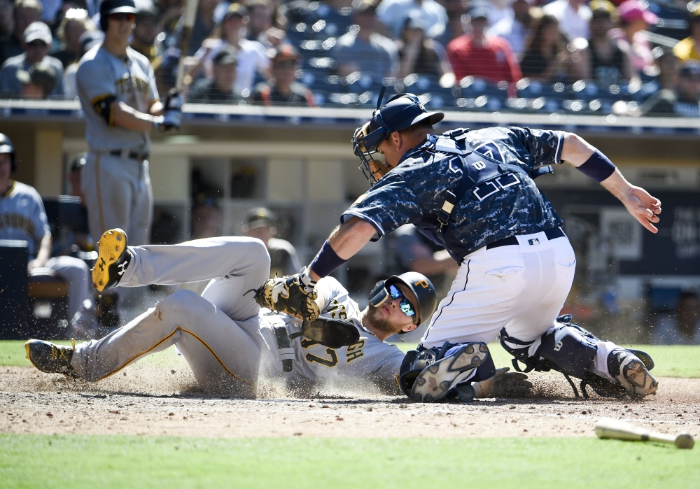 Austin Meadows No.17 of the Pittsburgh Pirates is tagged out at the plate by A.J. Ellis No.17 of the San Diego Padres during the seventh inning a baseball game at PETCO Park on July 1, 2018 in San Diego, California. — AFP