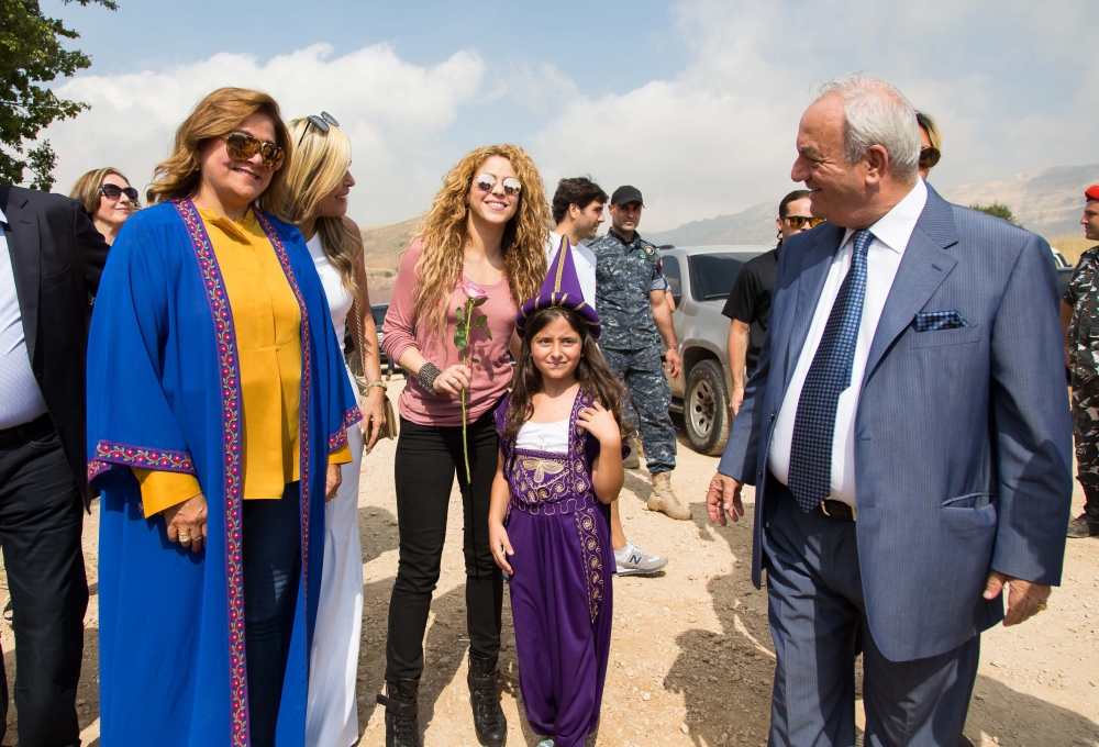 A handout picture provided by the Honorary Consulate of Lebanon in Barranquilla, Colombia, shows Colombian singer Shakira posing for a picture with a girl dressed in traditional Lebanese clothing during her visit to the northern mountain village of Tannourine where her paternal grandmother was born. - AFP