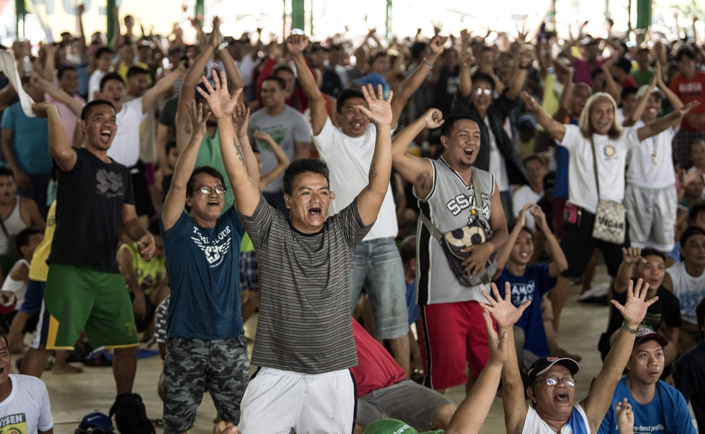 Filipino fans react as they watch Philippines’ Manny Pacquiao fight Argentina’s Lucas Matthysse during their world welterweight boxing championship bout in Kuala Lumpur, at a basketball court in Manila on Sunday. — AFP